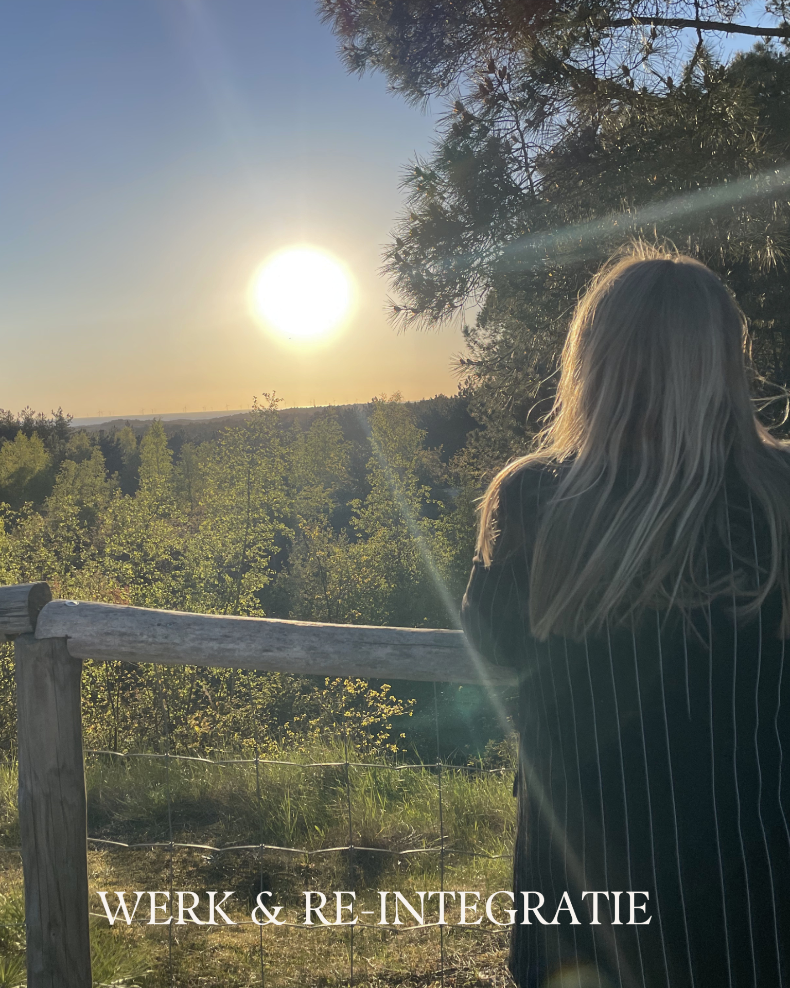 Vrouw in silhouet kijkt naar ondergaande zon boven heuvels en bomen, met zonnestralen door dennen.